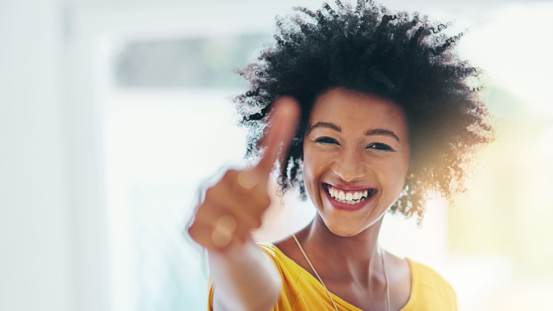 A young african american woman giving a thumbs up.